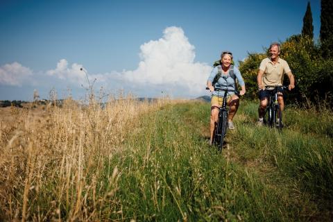UN HOMME ET UNE FEMME SE BALADANT A VELO DANS LA CAMPAGNE