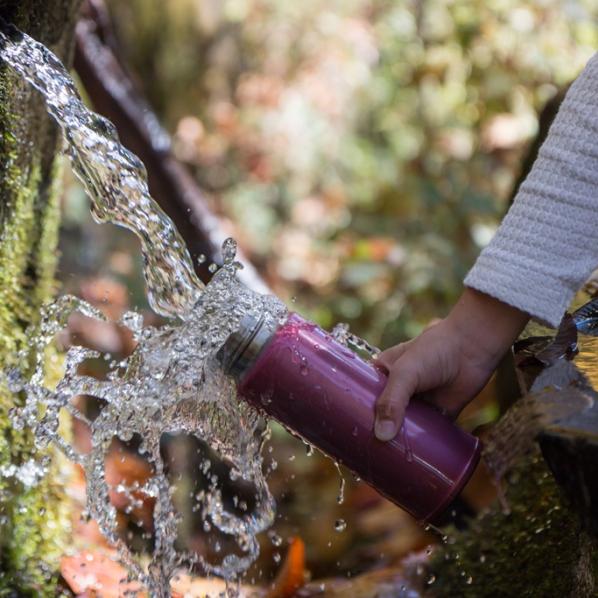Enfant remplissant sa gourde d'eau à la fontaine